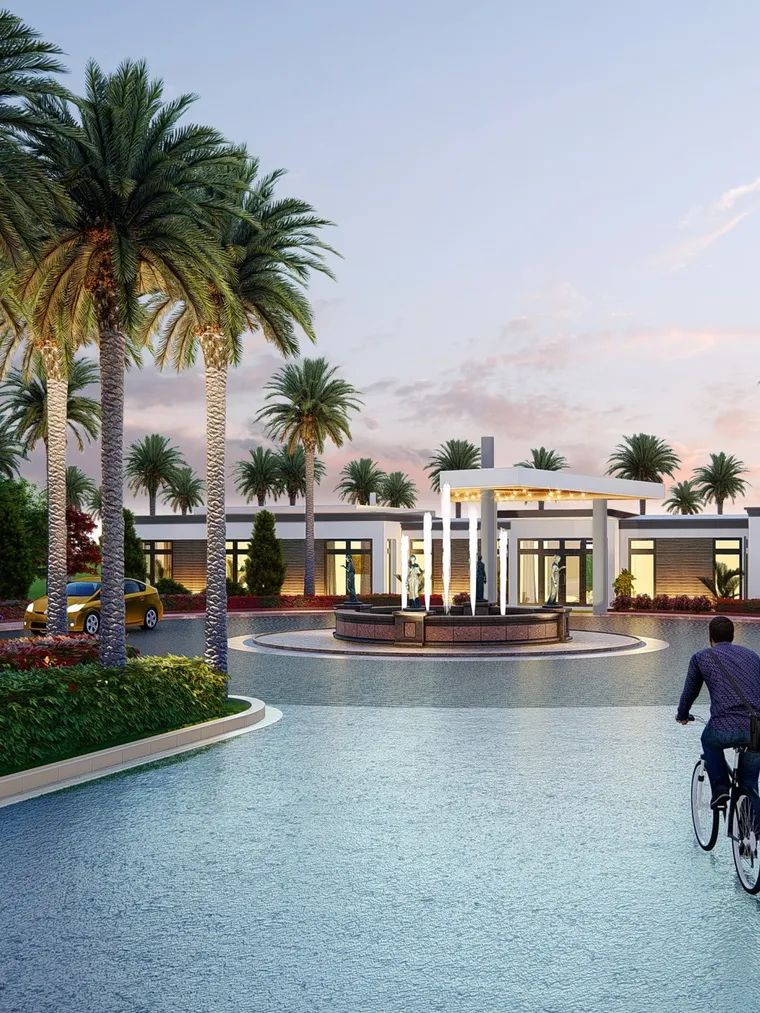 Clubhouse at dusk with palm-lined drive, fountain and cyclists